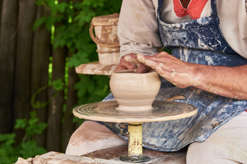 Potter forms a vase of clay on a potter's wheel