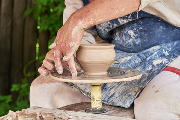 Potter forms a vase of clay on a potter's wheel