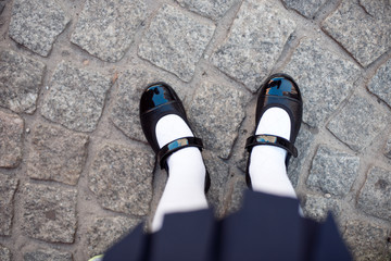 Close-up retro style image of school girl's feet in uniform.