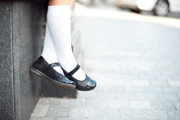 Close-up retro style image of school girl's feet in uniform.