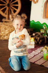 Two children, a girl and boy with Easter rabbit ears on head laugh and play. They hold colorful Easter eggs made of cardboard in their hands. Copy space.