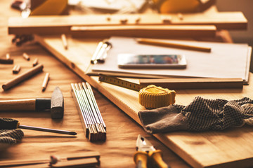 Various tools on carpentry woodwork workshop desk, selective focus