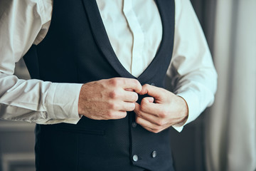 Businessman wears a jacket,male hands closeup,groom getting ready in the morning before wedding ceremony. Men Fashion