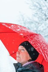 Portrait of beautiful adult female with umbrella in snow