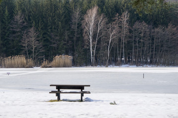 A table with benches on the water's edge © Emil