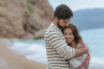 Obraz premium Young couple in love on the beach.Beautiful couple in white. Lovers holding hands and hugging