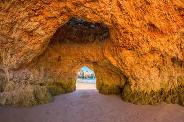 Famous caves in a beach rock formation in the Algarve, Portugal. Through the cave you can see the ocean.
