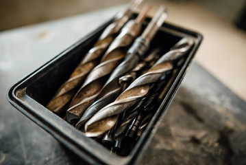 set of steel milling cutters for milling cutters in a rectangular box on the old black table,...