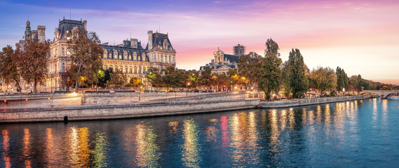 Beautiful colors near Hotel de Ville at dusk with Seine river - Paris, France. Coral color sky.