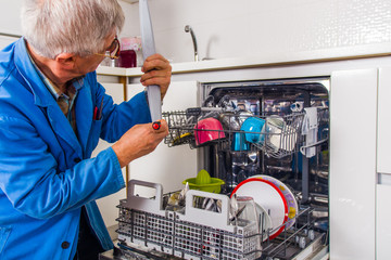 Service man fixing dish washer machine
