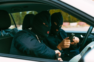 bank robbers putting their mask on prepared to do their next robbery,checking and loading their...