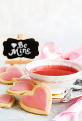 Heart shaped shortbread cookies and cup of red tea, Valentine concept