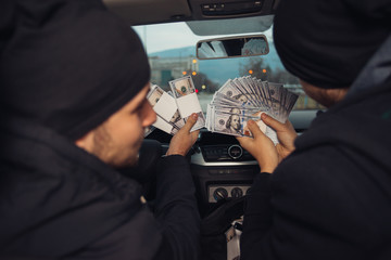 Two happy bank robbers celebrating their successful hit while sitting in the car they used for the...