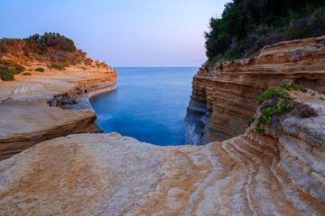 Famous Canal d'Amour beach with beautiful rocky coastline in amazing blue Ionian Sea at sunrise in Sidari holiday village on Corfu island
