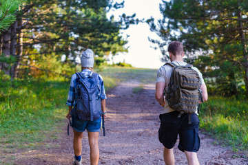 Obraz premium Young couple walking in the forest. Hiking concept in the mountain in summer