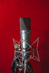 Microphone for recording music in the studio. Red background.