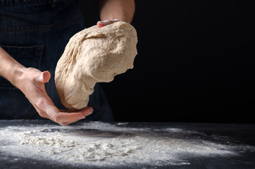 Woman kneading dough on sprinkled with flour table. Yeast dough for bread, rolls, pizza, focaccia...