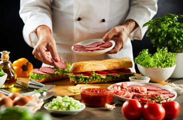 Chef preparing a crusty baguette sandwich
