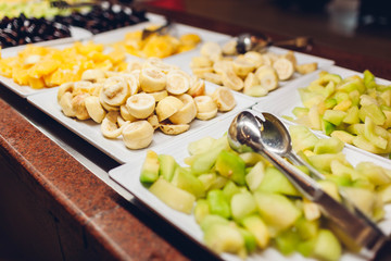 Assortment of fresh fruits displayed in hotel buffet. Variety of tropical exotic food in canteen...