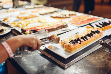 Assortment of fresh desserts displayed in hotel buffet. Variety of cakes in canteen ready for dinner