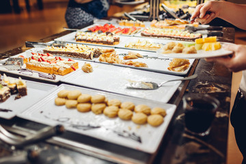 Assortment of fresh desserts displayed in hotel buffet. Variety of cakes in canteen ready for dinner