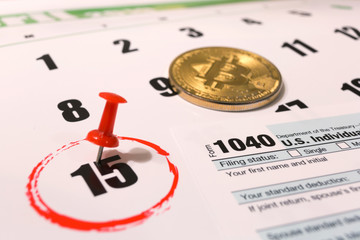 Bitcoin and 2019 calendar with 1040 income tax form for 2018 showing tax day for filing on April 15