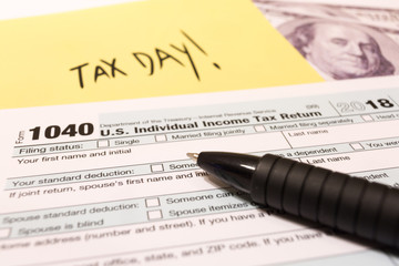 Obraz premium 1040 income tax form with pen for 2018 showing tax day for filing on April 15