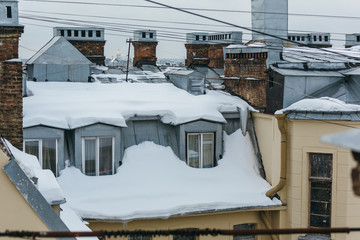 Snow-covered windows in the attic apartment, roof leak, roof cover damage, high precipitation,...
