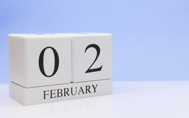 February 02st. Day 02 of month, daily calendar on white table with reflection, with light blue background. Winter time, empty space for text