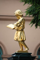 Obraz premium Goldener Engel mit einem aufgeschlagenen Buch in der Hand