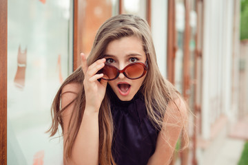 Surprised shocked frustrated young woman holding sunglasses down - obrazy, fototapety, plakaty