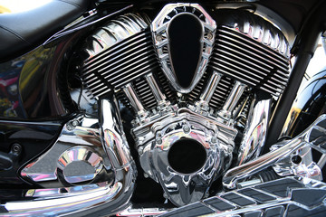 Close up of a shiny chrome motorcycle engine assembly and pipes.