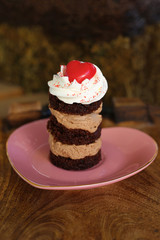 Chocolate mini cake with whipped cream and a red heart