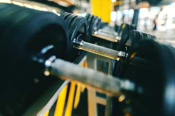 Close up of dumbbells in the row. Gym interior.