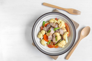 top view of stir fried pork belly and vegetable with soy sauce in a ceramic dish. homemade style food concept.
