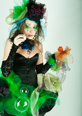 fashion model with creative make-up blowing soap bubbles