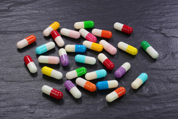  Colorful medical capsules on black background .