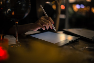 girl designer illustrator working on new pro tablet with stylus at cafe