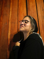 Obraz premium Young Hispanic girl with confident expression and cool attitude, with good style black clothes. Wood background.