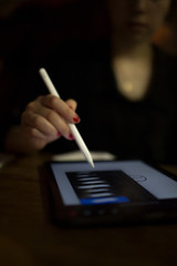 girl designer illustrator working on new pro tablet with stylus at cafe