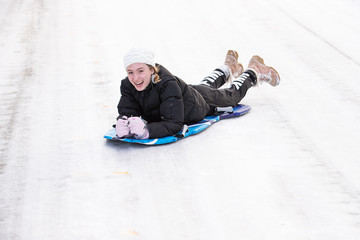 Fototapeta na wymiar teenage girl on a snow sled