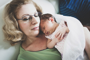 Newborn baby girl in grandmothers arms.