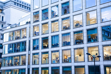 illuminated offices at night people working late