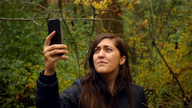 Woman Searches For Phone Signal In The Woods