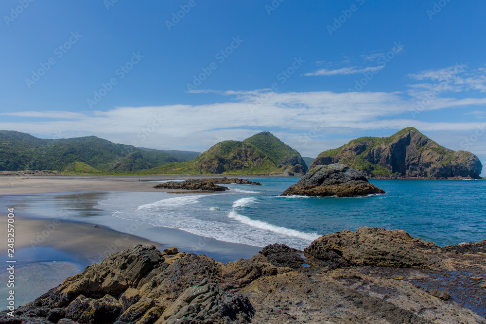 Wall mural view of the whatipu beach from the ninepin rock to the paratutae island. white waves on the beach an