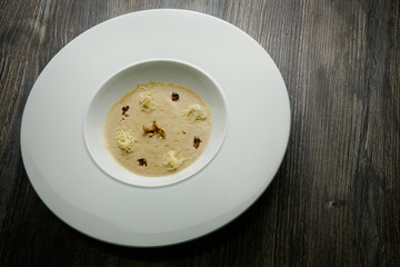 beige seafood cream soup decorated with dried squid and soy sauce