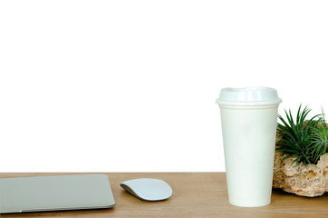 Wooden desk in office with laptop computer, white mouse, coffee tumbler and Tillandsia airplant which is modern plant that no need much water, decorate on the desk isolated on white background.