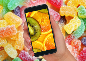 healthy nutrition and fresh fruits versus sweet citrus candy and sugary unhealthy candy in fresh...