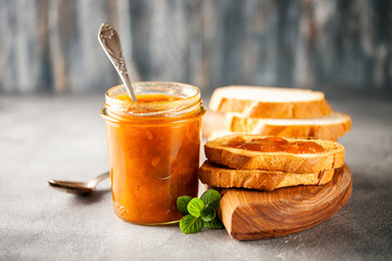 Apricot jam in a jar and fresh fruits