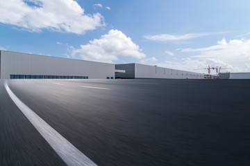 Road asphalt pavement and modern factory warehouse..